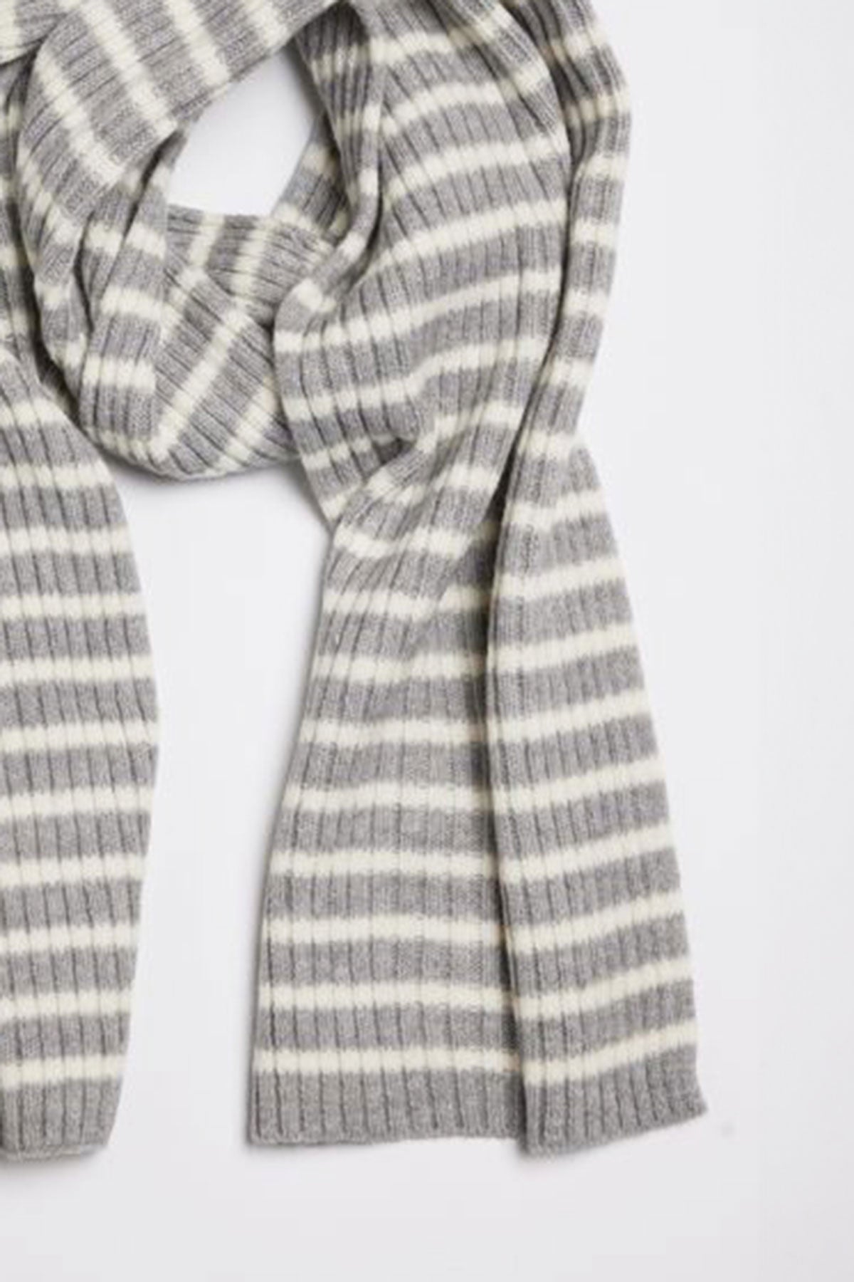   The BOLTON STRIPE SCARF by Velvet by Graham & Spencer, featuring a gray and white striped ribbed knit design, is laid out flat against a white background. 