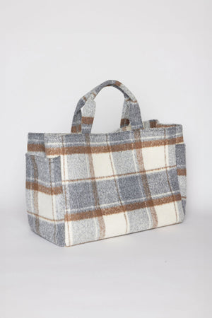 The PLAID TOTE by Velvet by Graham & Spencer is a rectangular woolen bag featuring a gray, brown, and white plaid pattern, complete with two short handles.