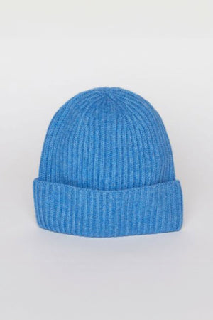 The CASHMERE RIB BEANIE by Velvet by Graham & Spencer, featuring a folded brim in a striking blue knit, is displayed against a plain white background.