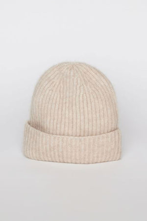 A beige CASHMERE RIB BEANIE by Velvet by Graham & Spencer, featuring a ribbed knit and folded cuff, displayed against a plain, light gray background.