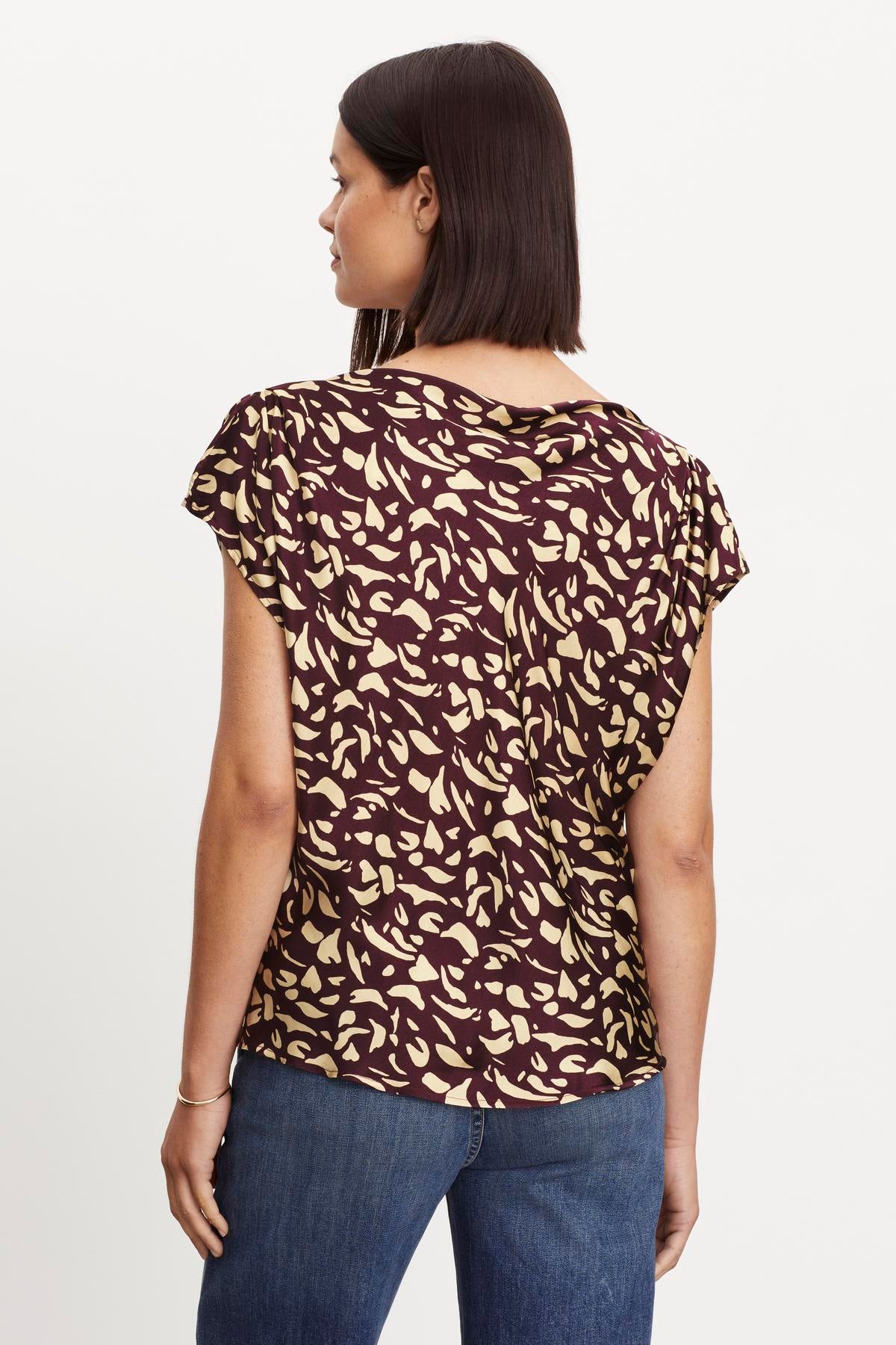The back view of a woman wearing a Velvet by Graham & Spencer DEVI PRINTED SATIN BLOUSE.-35696205496513