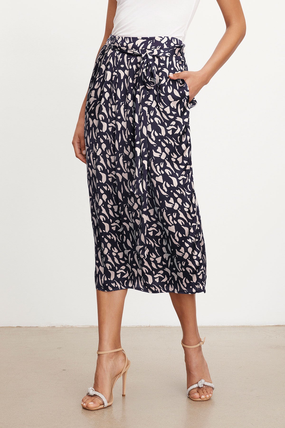 Woman wearing JUNO PRINTED SATIN SKIRT by Velvet by Graham & Spencer and strappy heels.-36290648998081