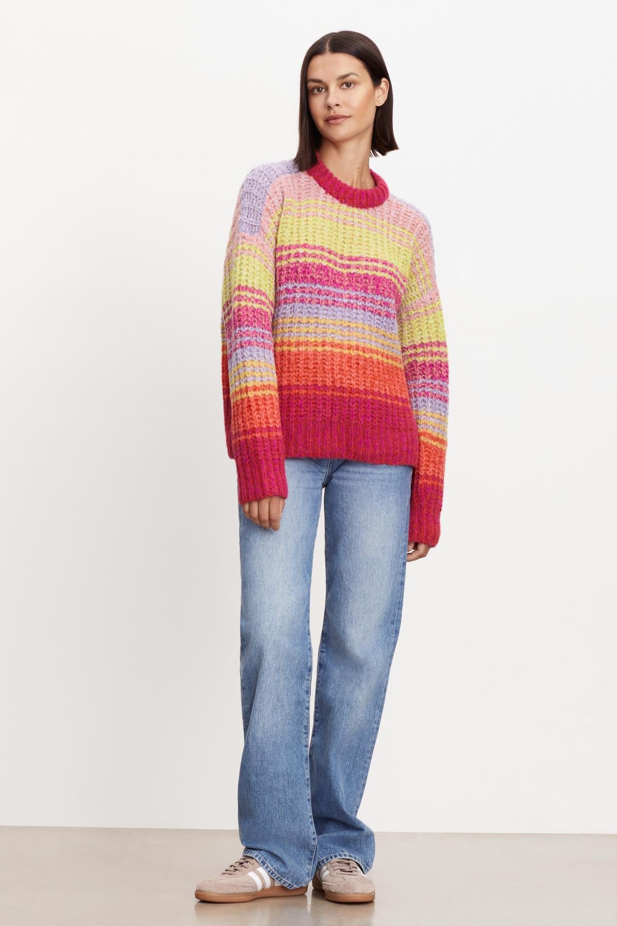 A woman wearing a cozy Velvet by Graham & Spencer Brandy Striped Crew Neck Sweater.-35624145158337
