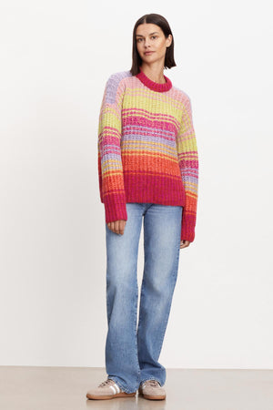 A woman wearing a cozy Velvet by Graham & Spencer Brandy Striped Crew Neck Sweater.