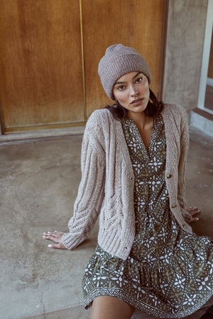 A woman wearing a Velvet by Graham & Spencer HAZEL ALPACA CABLE KNIT CARDIGAN and dress.