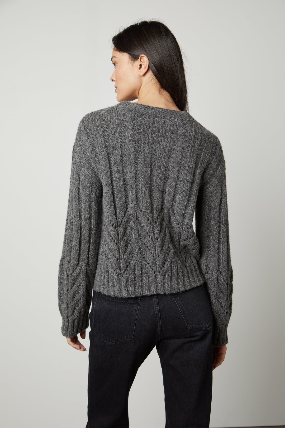 The back view of a woman wearing a Hazel Alpaca Cable Knit Cardigan by Velvet by Graham & Spencer.-26897822187713