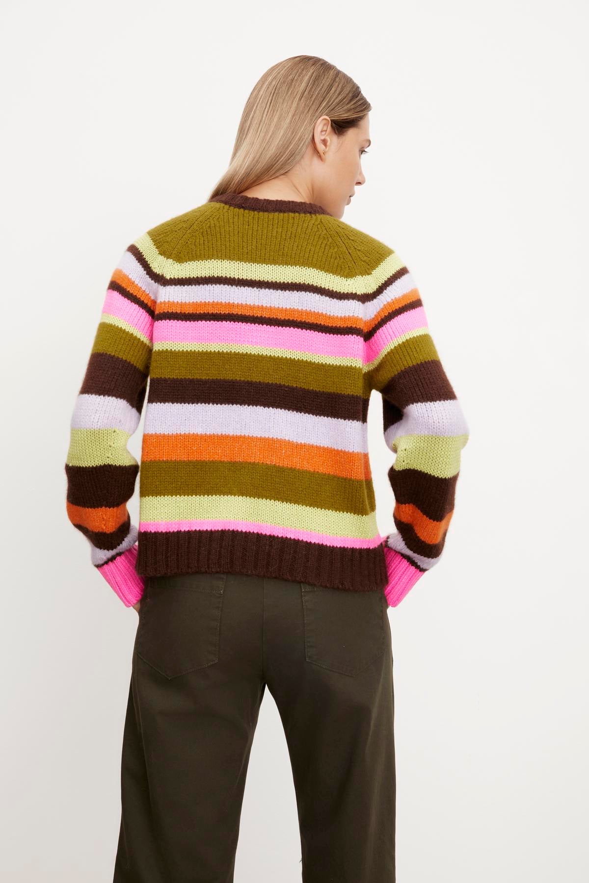 The back view of a woman wearing a NESSIE STRIPED CREW NECK SWEATER by Velvet by Graham & Spencer.-35654464864449