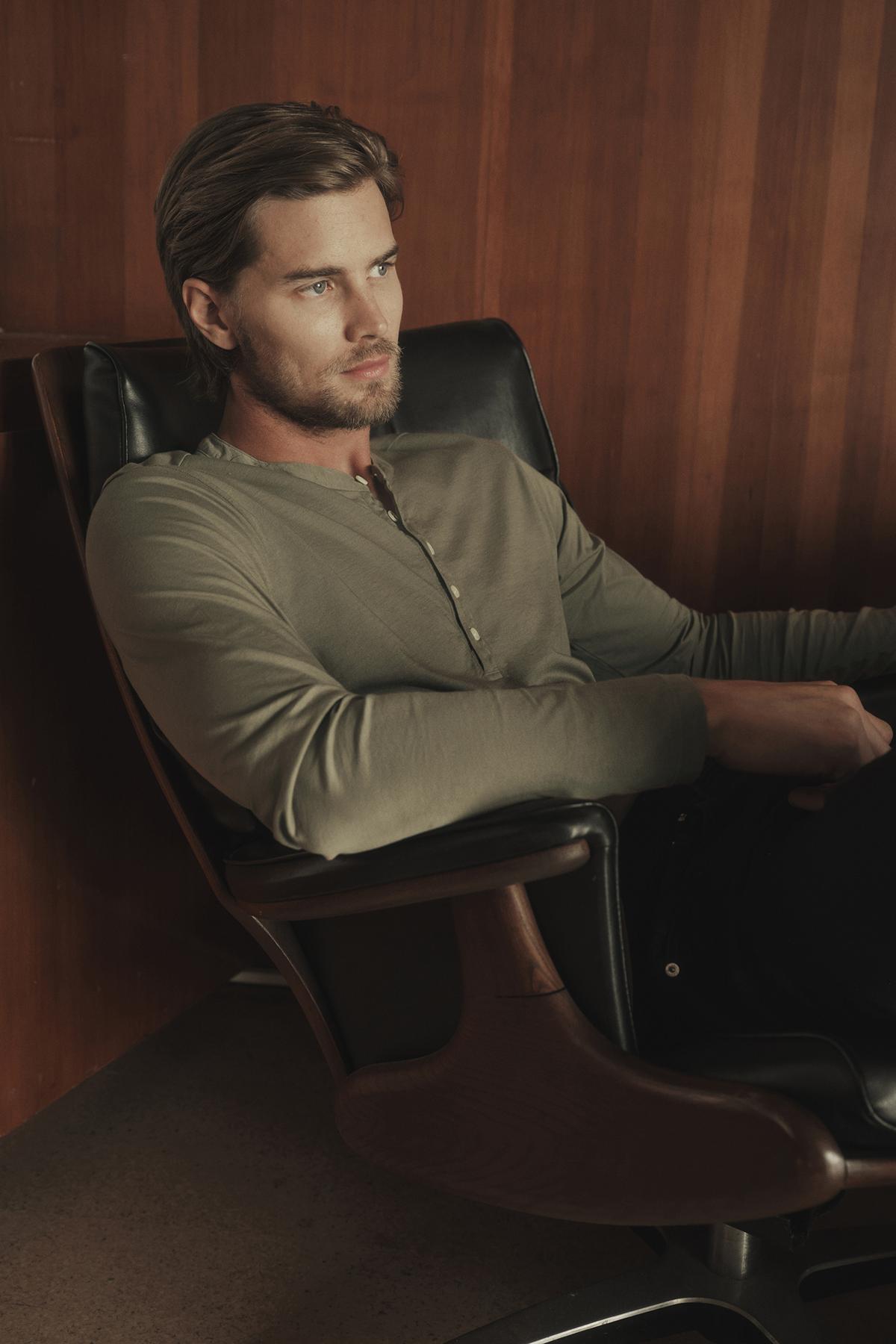   A man sitting in a chair wearing Velvet by Graham & Spencer ALVARO COTTON JERSEY HENLEY in cactus green 