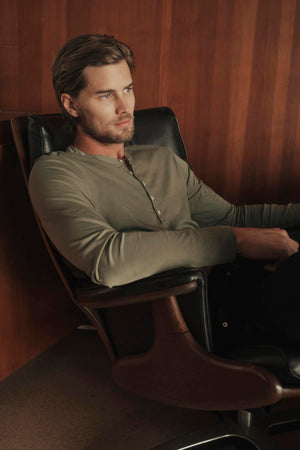 A man sitting in a chair wearing Velvet by Graham & Spencer ALVARO COTTON JERSEY HENLEY in cactus green
