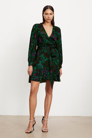 The model is wearing a BRIDGET PRINTED SATIN WRAP DRESS by Velvet by Graham & Spencer with an adjustable tie waist.