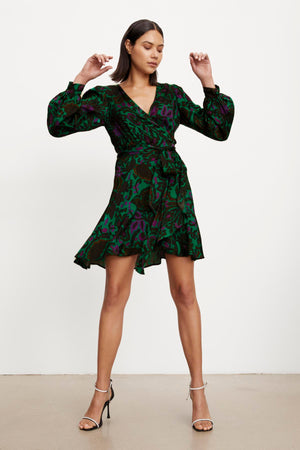 The model is wearing a Velvet by Graham & Spencer BRIDGET PRINTED SATIN WRAP DRESS with an adjustable tie waist.