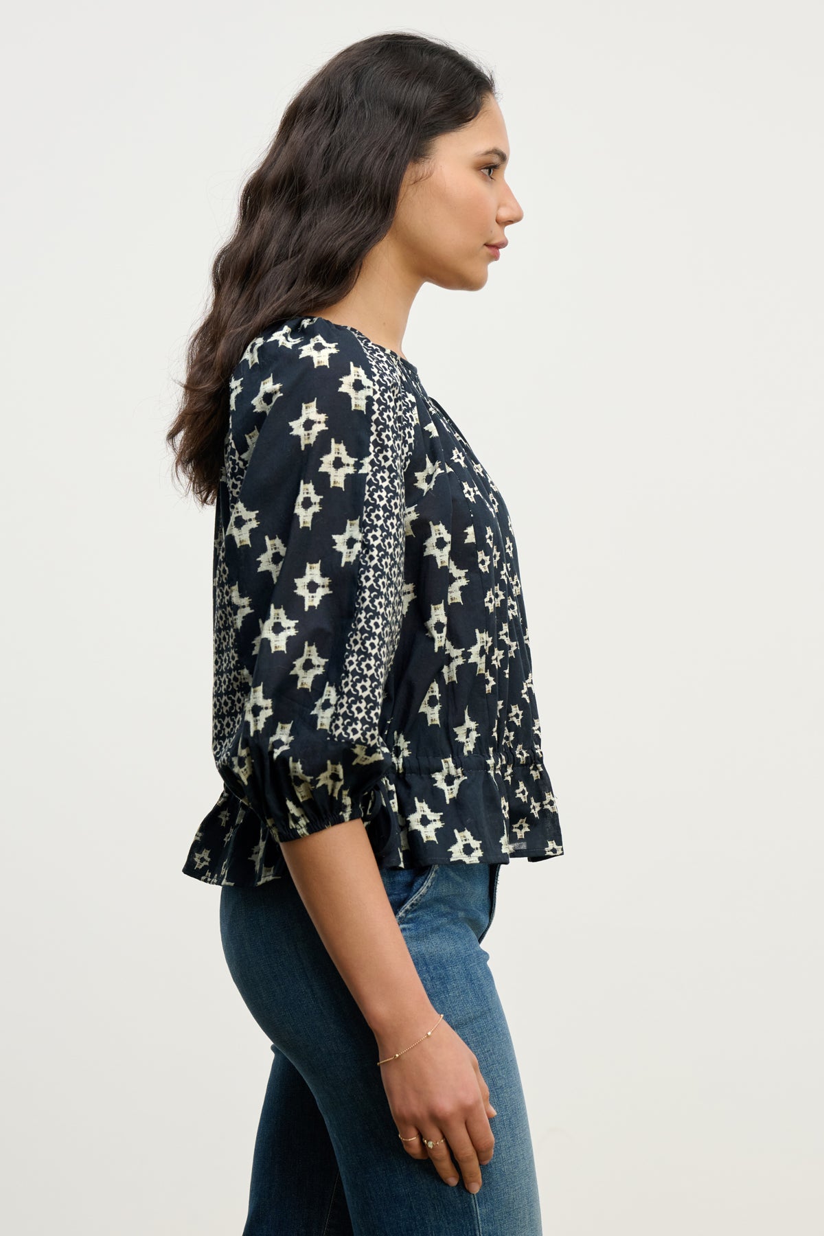 A woman wearing the ADELAIDE TOP by Velvet by Graham & Spencer, a black and white smocked blouse.