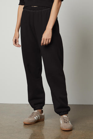 A woman seeking comfort and warmth in Velvet by Graham & Spencer CELESTA SWEATPANT and a cozy sweater.