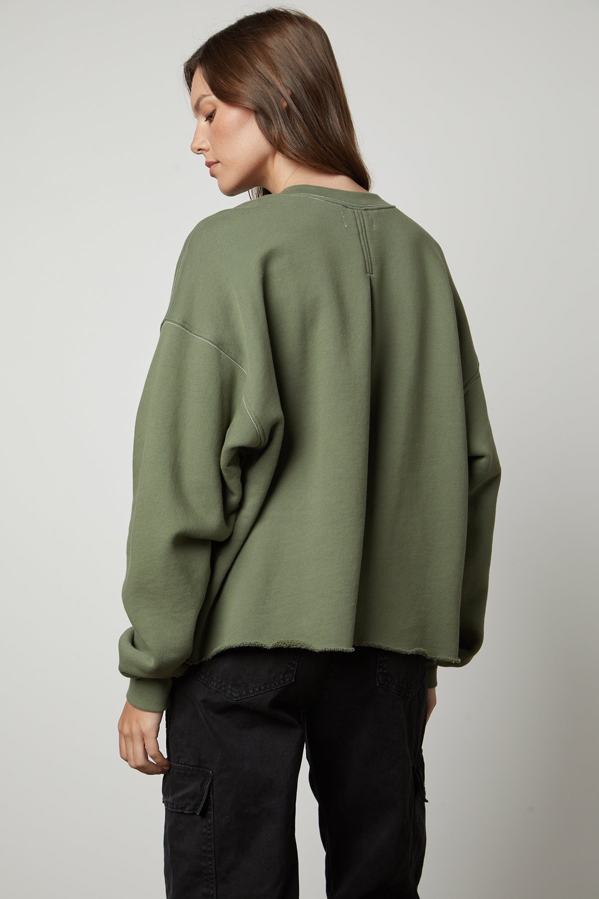 The back view of a woman wearing the Velvet by Graham & Spencer DAX OVERSIZED SWEATSHIRT made of cotton fleece.-35503748939969