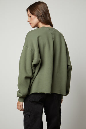 The back view of a woman wearing the Velvet by Graham & Spencer DAX OVERSIZED SWEATSHIRT made of cotton fleece.