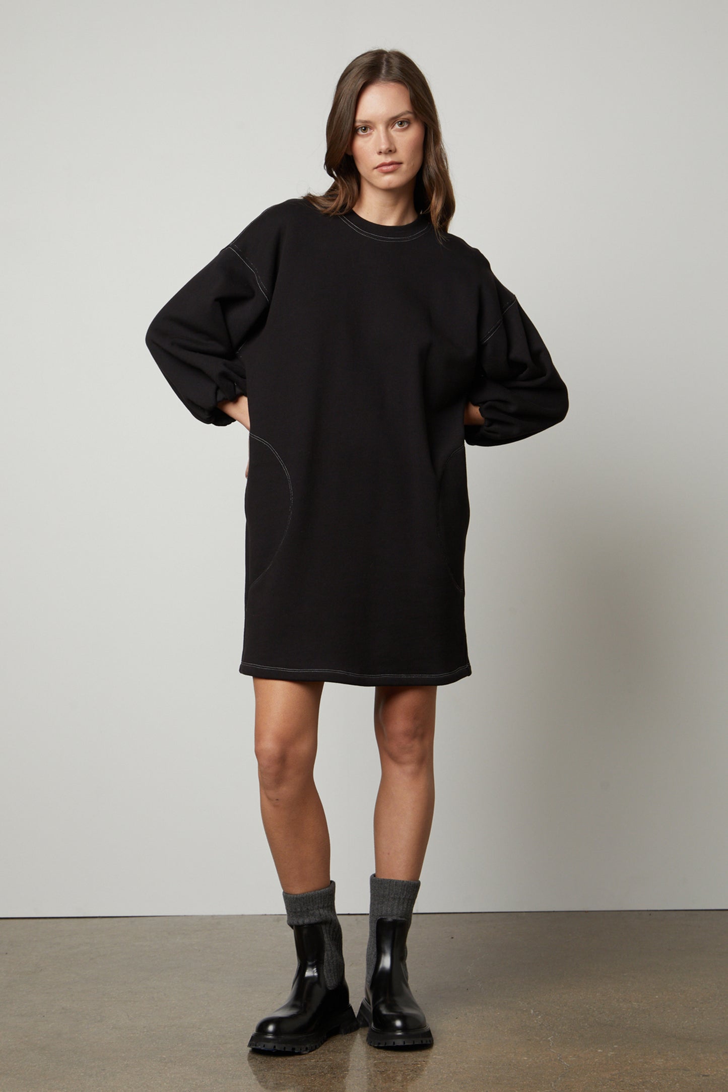 A model wearing a Velvet by Graham & Spencer JENSEN PUFF SLEEVE DRESS and black boots.-26883616833729
