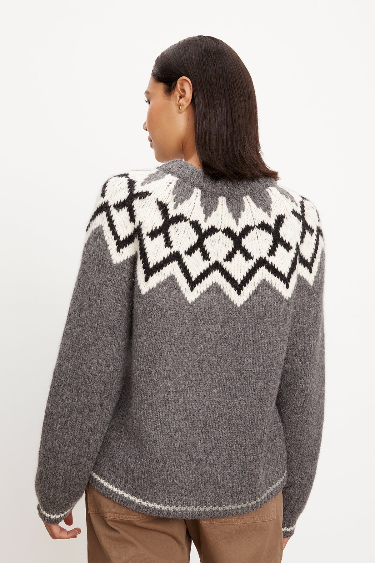   The back view of a woman wearing a Velvet by Graham & Spencer ALEXA FAIR ISLE CREW NECK SWEATER with a fair isle design. 
