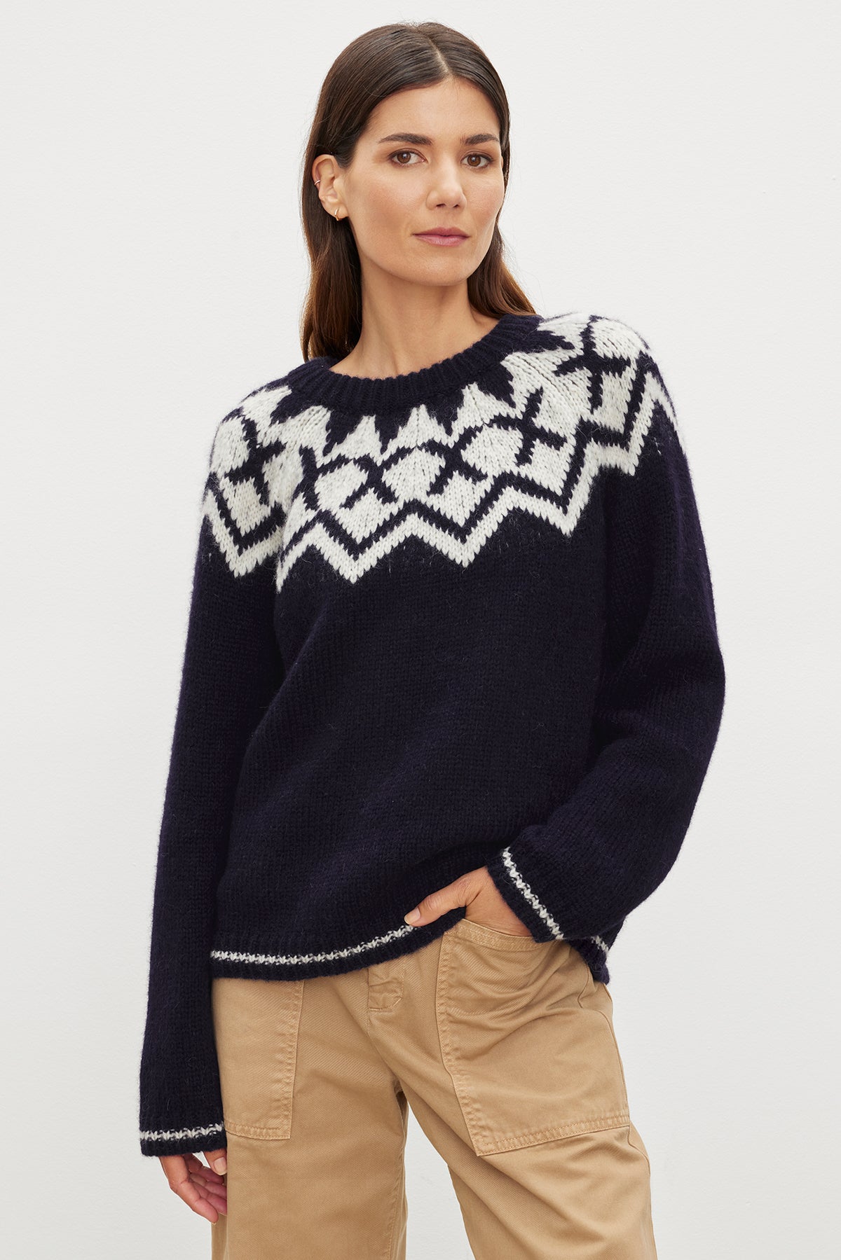A woman wearing a navy Velvet by Graham & Spencer alpaca blend sweater with the ALEXA FAIR ISLE CREW NECK design and tan pants.-35572030046401