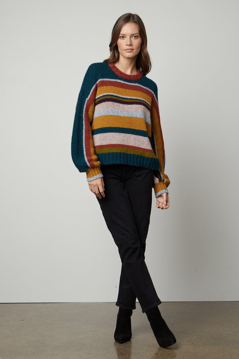 A model wearing a cozy Velvet by Graham & Spencer SAMARA STRIPED CREW NECK SWEATER.