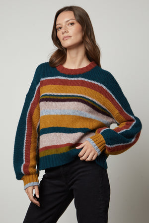 A woman wearing a cozy and elegant Velvet by Graham & Spencer SAMARA STRIPED CREW NECK SWEATER.