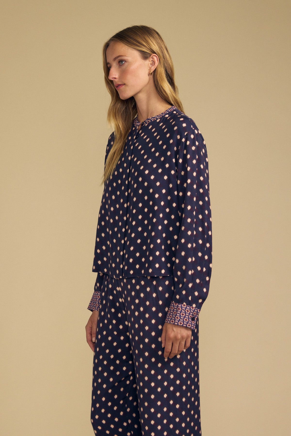 ERIKA PRINTED BLOUSE by Velvet by Graham & Spencer, a long-sleeved navy blue viscose button-front blouse featuring a repeating light pink diamond pattern and decorative bands at the collar and cuffs.-46488190058689
