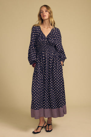 Velvet by Graham & Spencer MALLORY PRINTED DRESS: a navy blue midi dress featuring a light diamond print, V-neckline, smocked waist, and border print hem.