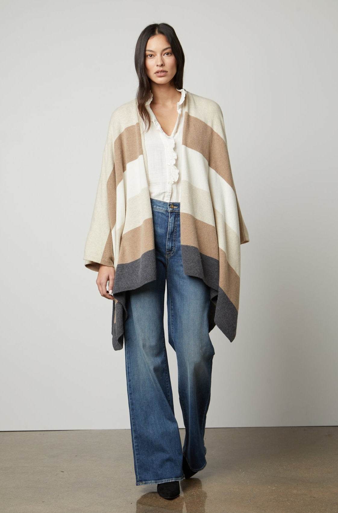 A model wearing a JONAS STRIPED OPEN FRONT PONCHO by Velvet by Graham & Spencer.-26872399986881