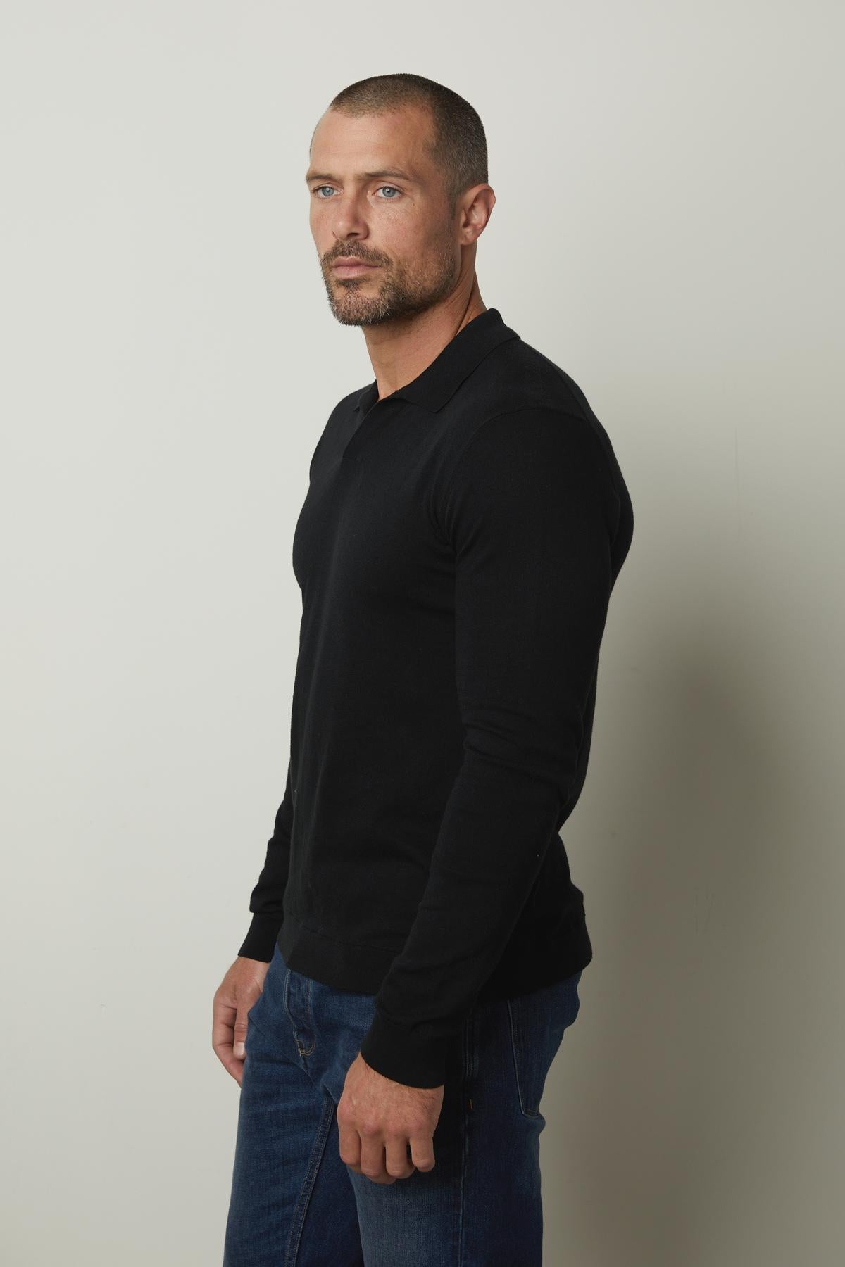 A man wearing a black Velvet by Graham & Spencer GENO LINEN BLEND POLO and jeans.-26679208411329