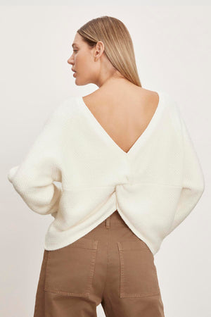 The back view of a woman wearing a Velvet by Graham & Spencer CAITLYN BOUCLE RAGLAN SWEATER.