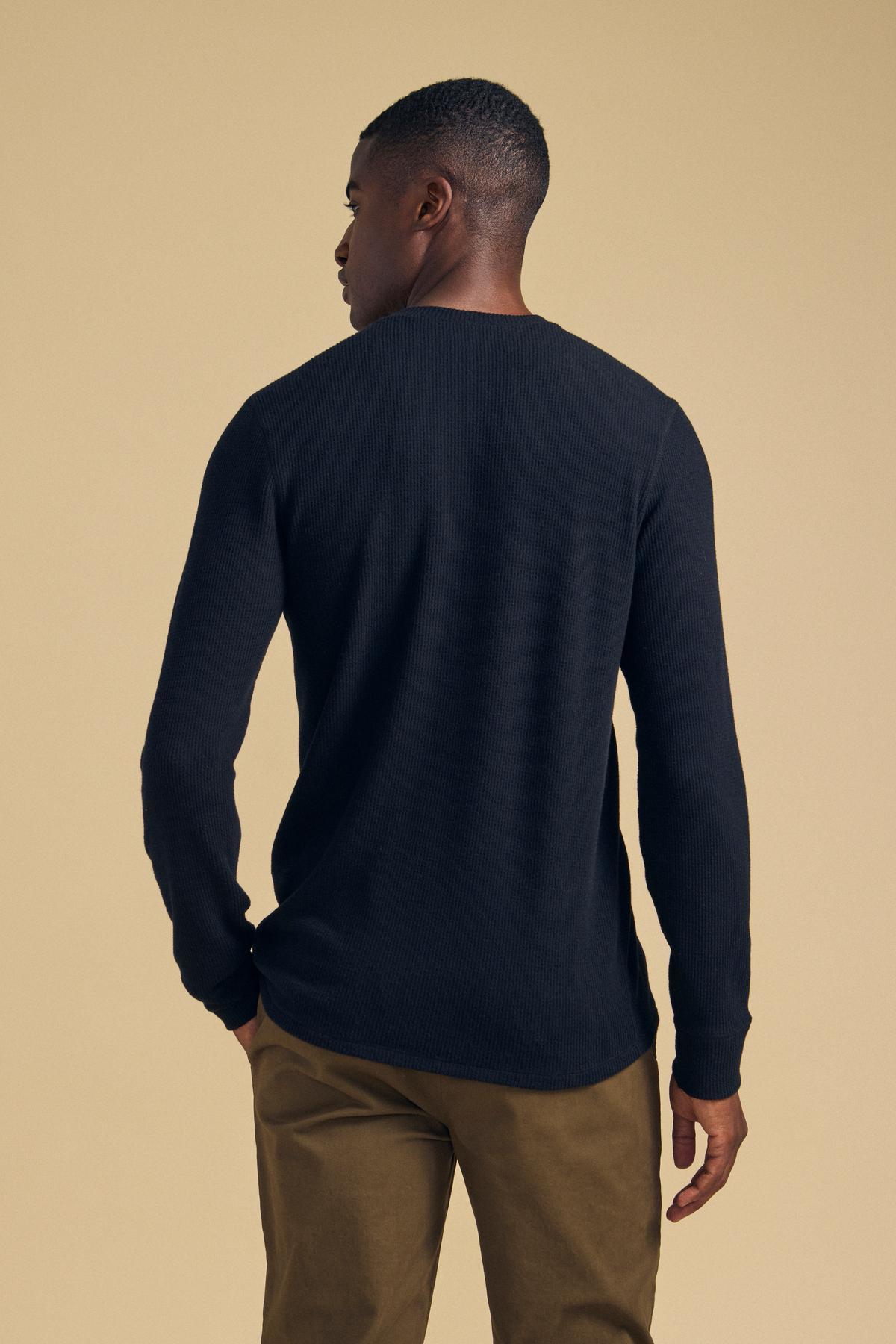 Rear view of a person wearing a long-sleeved, black brushed thermal ROEN THERMAL HENLEY and brown trousers.-46288507666625