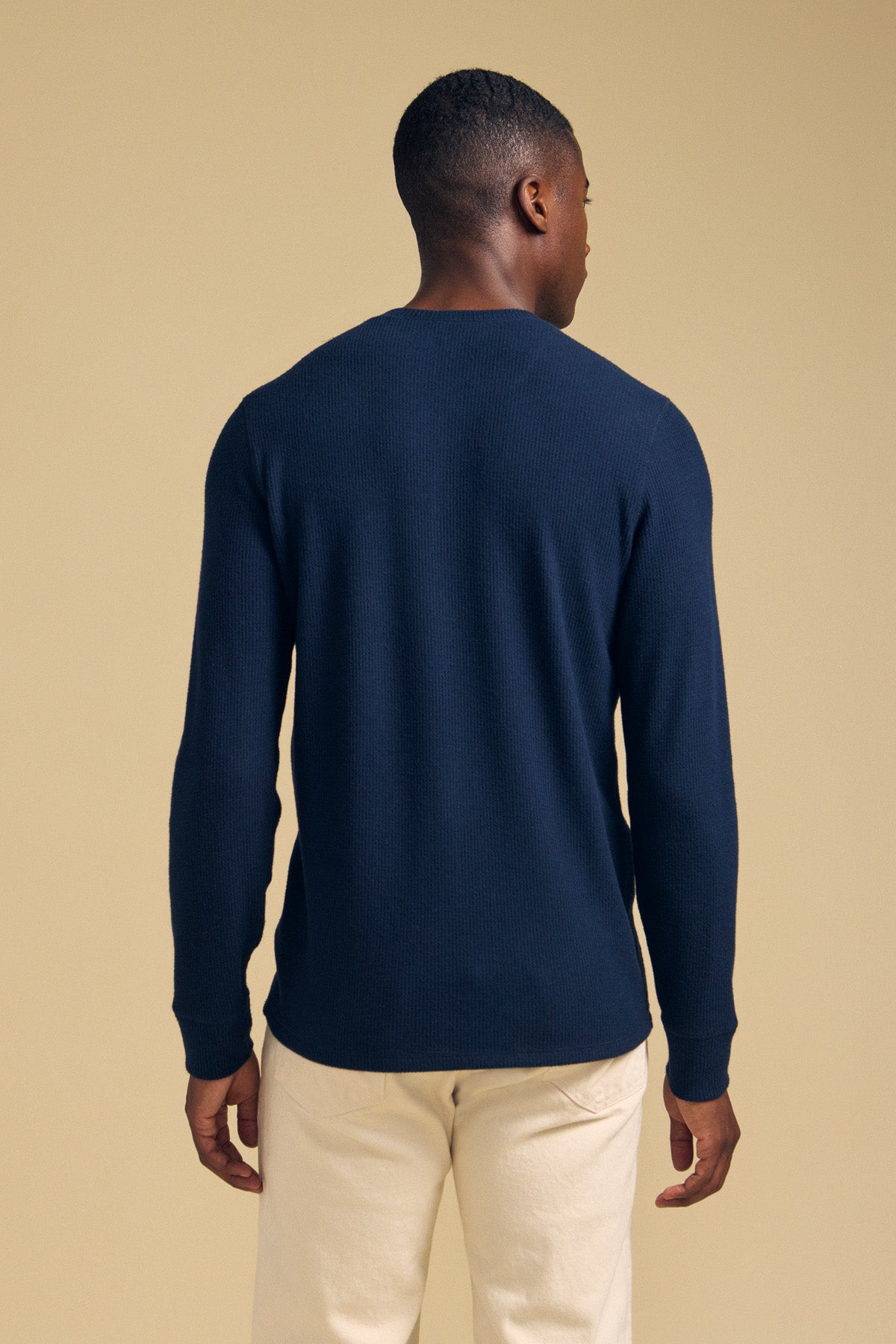 Back view of a person wearing a navy ROEN THERMAL HENLEY and light-colored pants.