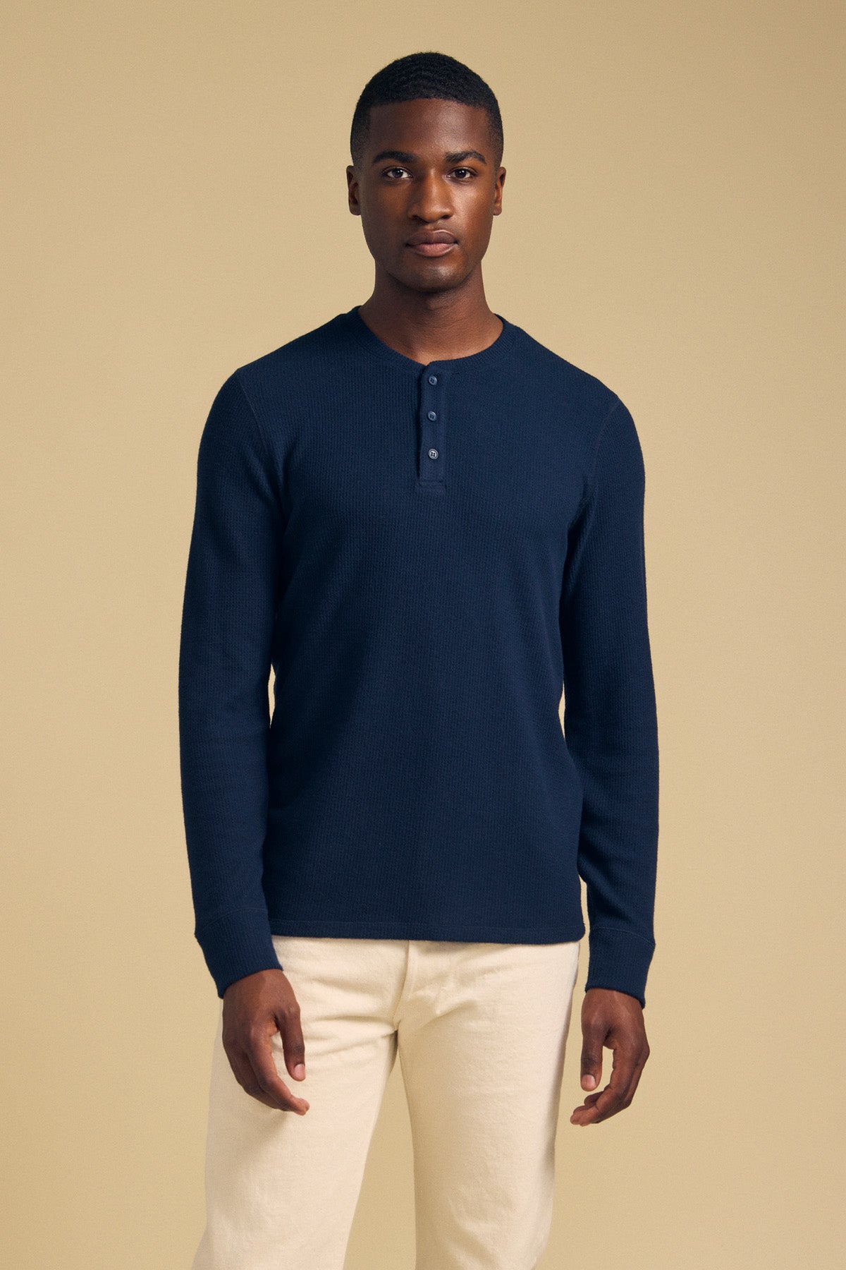 A man wearing a navy blue ROEN THERMAL HENLEY shirt with a three-button placket.