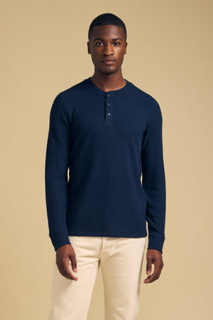 A man wearing a navy blue ROEN THERMAL HENLEY shirt with a three-button placket.