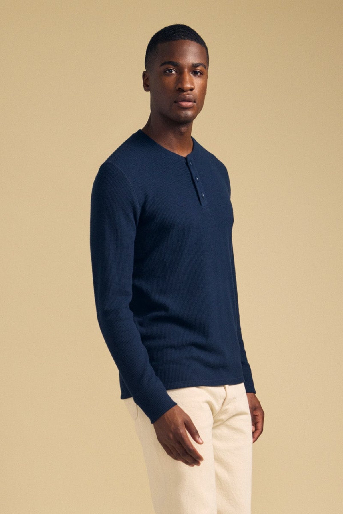 A man wearing a navy blue ROEN THERMAL HENLEY by Velvet by Graham & Spencer, a brushed thermal shirt with a three-button placket.-46288506159297