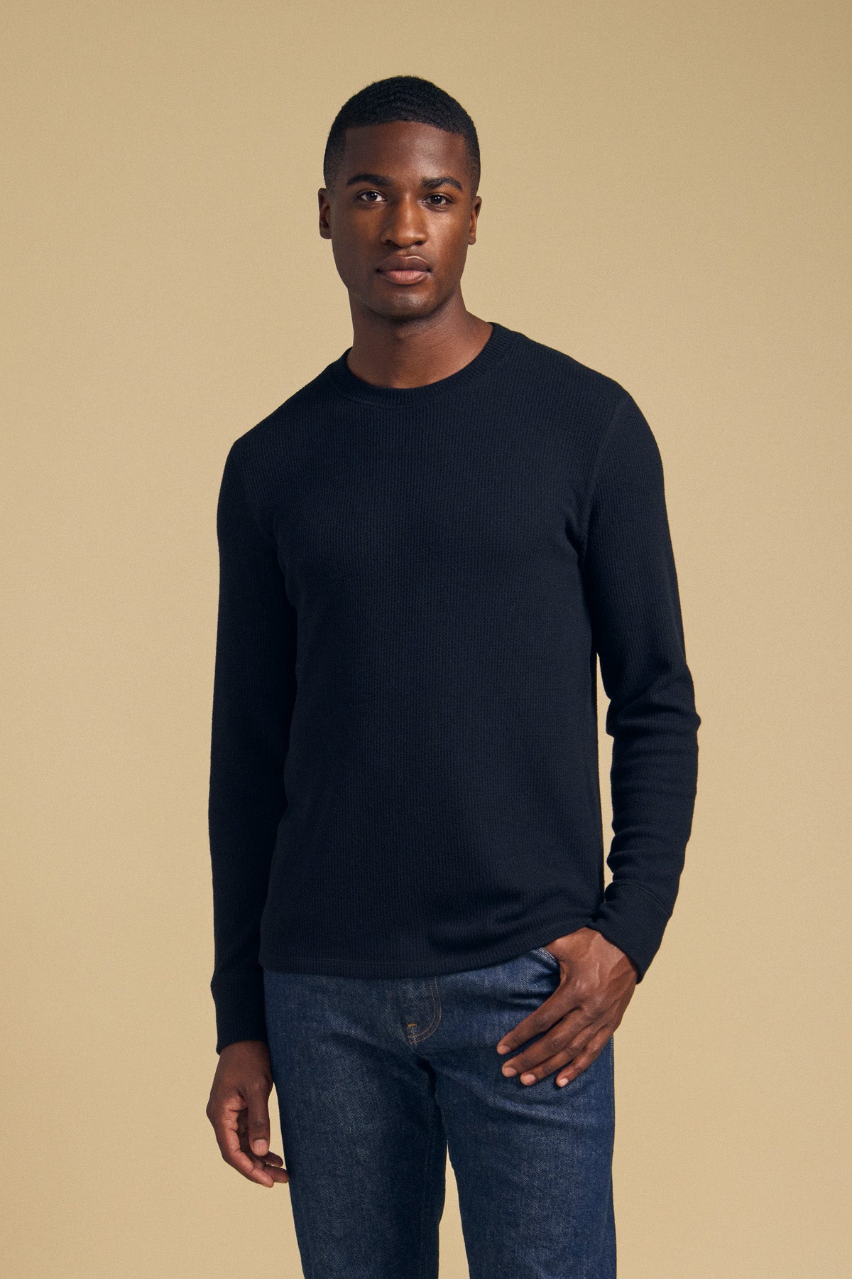 A man wearing a black brushed TOLLIVER THERMAL CREW PULLOVER by Velvet by Graham & Spencer and blue jeans.-46288499998913