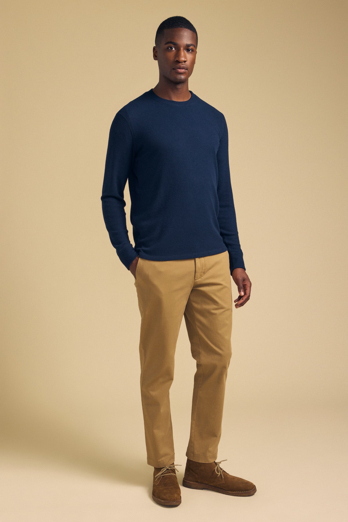 A man wearing a navy blue Velvet by Graham & Spencer TOLLIVER THERMAL CREW PULLOVER, tan chinos, and brown suede chukka boots.-46288499835073