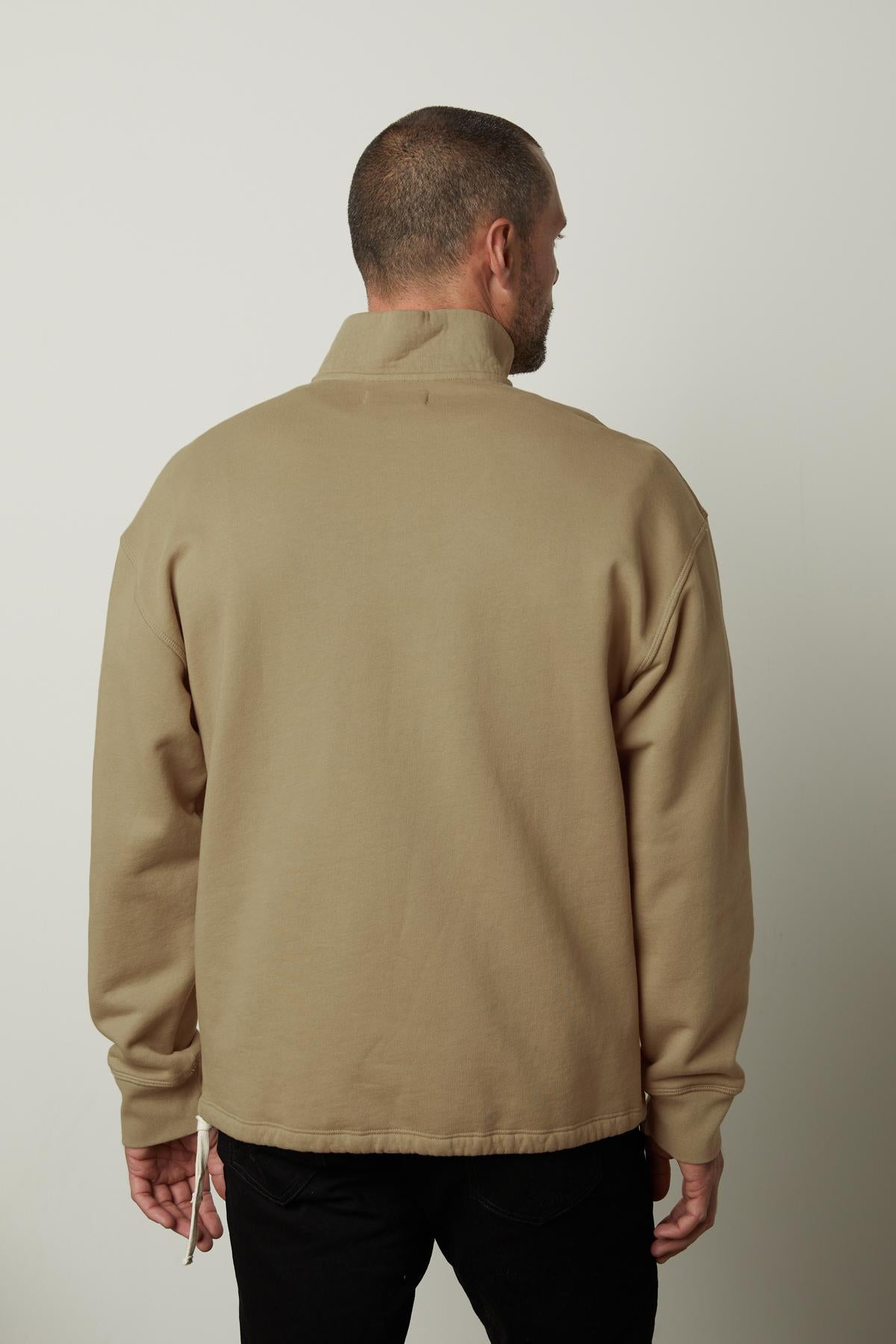   The back view of a man wearing a Velvet by Graham & Spencer BOSCO QUARTER-ZIP SWEATSHIRT made of soft brushed fleece. 