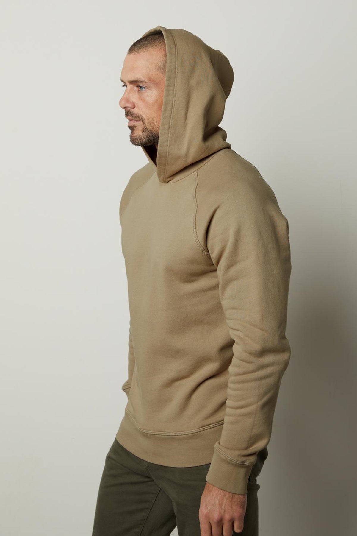 A man wearing a HOPKIN PULLOVER HOODIE crafted for comfort from Velvet by Graham & Spencer.-35547534000321
