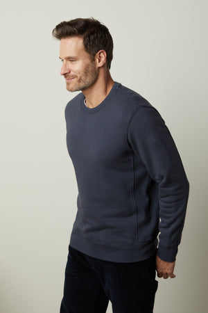 A man wearing a Velvet by Graham & Spencer KING CREW NECK SWEATSHIRT and pants.