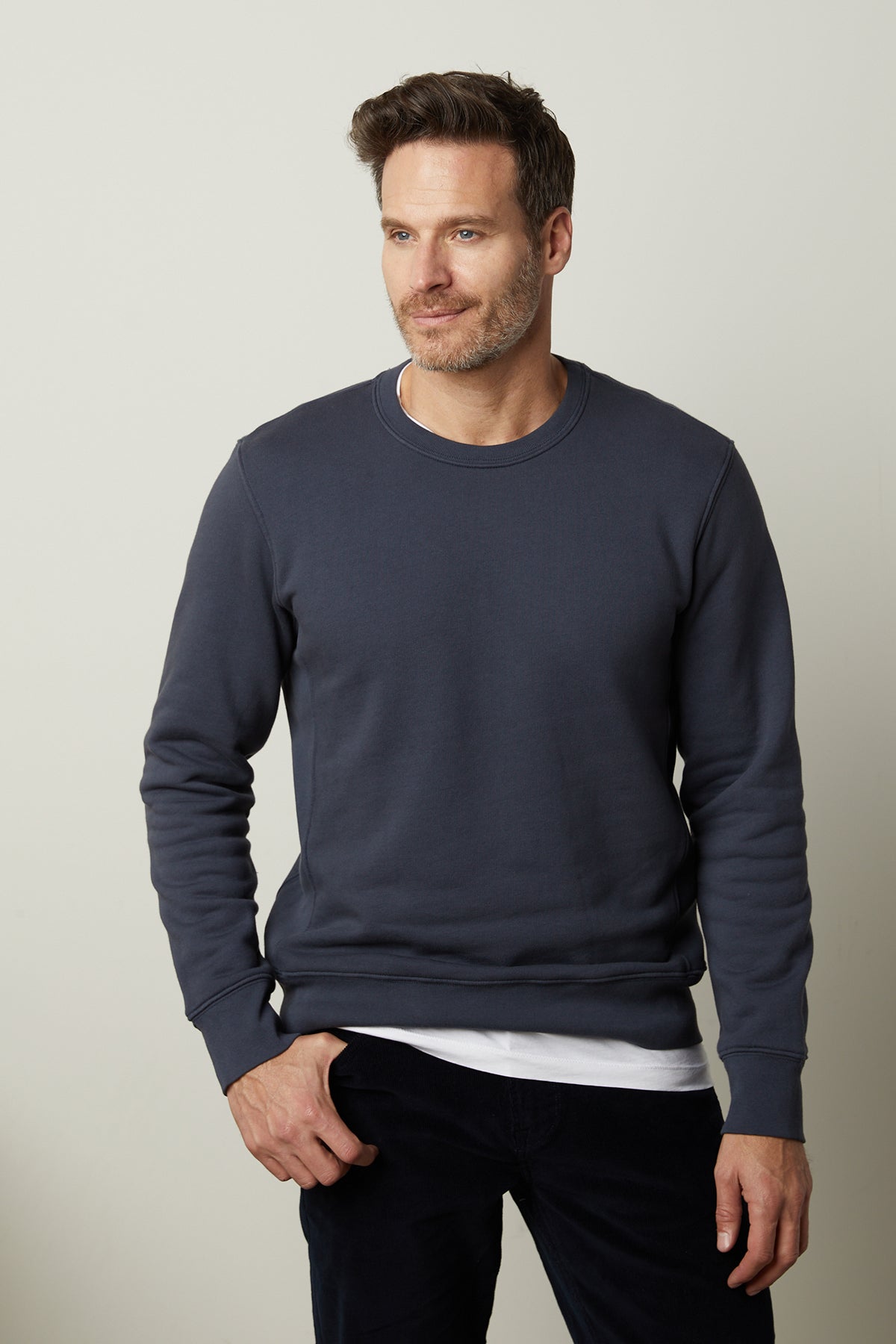   A man wearing a Velvet by Graham & Spencer KING CREW NECK SWEATSHIRT and black pants. 
