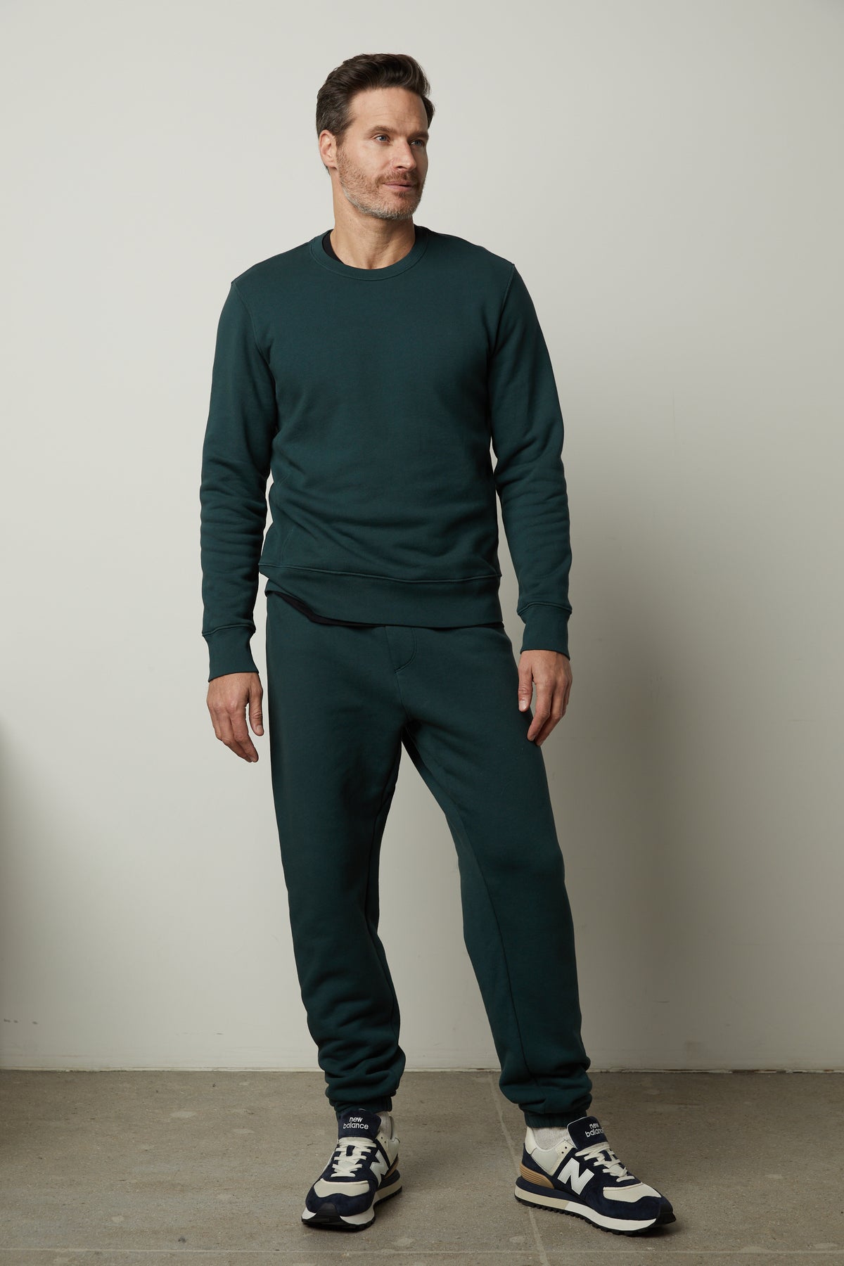   A man wearing a green Velvet by Graham & Spencer Montgomery Brushed Fleece Sweatpant and elastic waist jogging pants. 