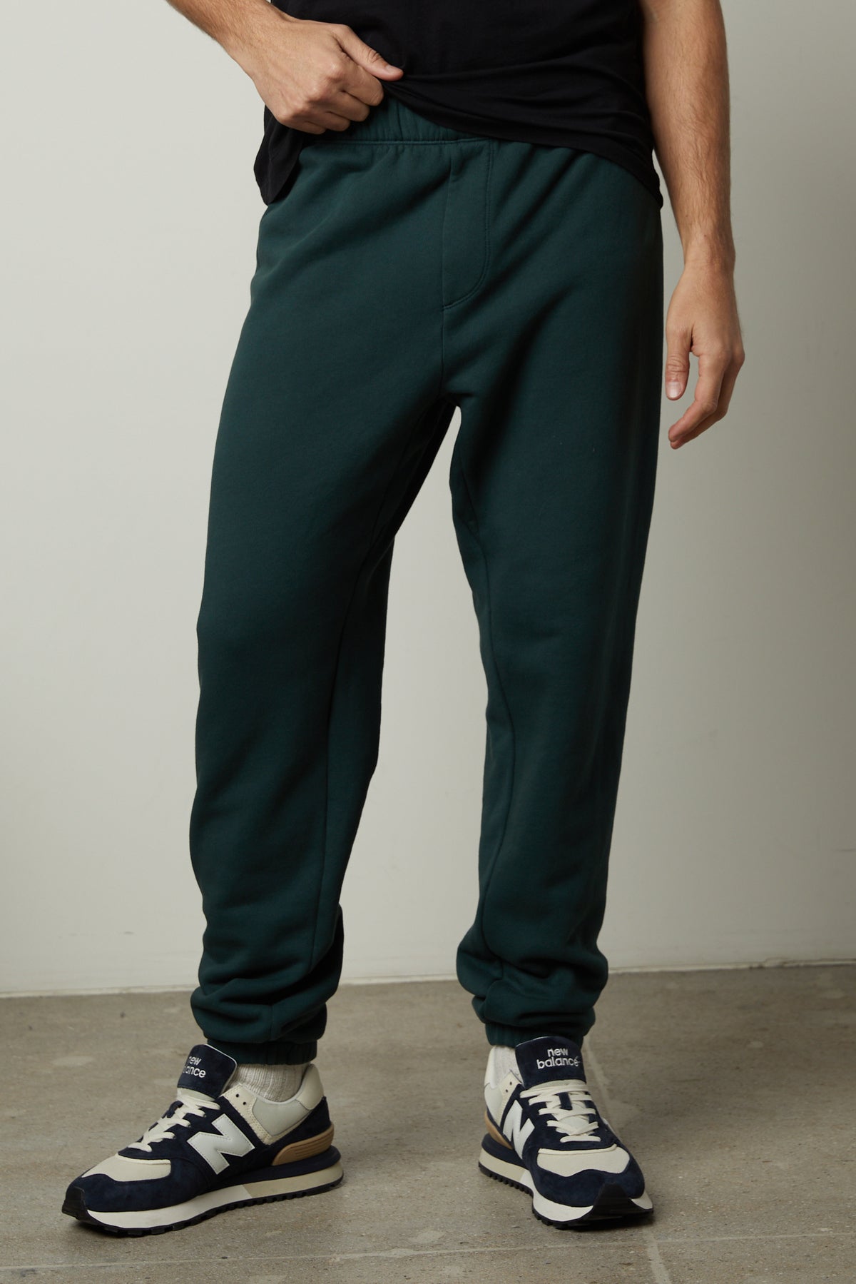  A man wearing Velvet by Graham & Spencer's MONTGOMERY BRUSHED FLEECE SWEATPANT with elastic waist and cuffs. 