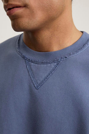 A person wearing the Forrest Sweatshirt by Velvet by Graham & Spencer appreciates its relaxed fit and ribbed trims, crafted from heavyweight cotton fleece, with visible stitching details around the collar.