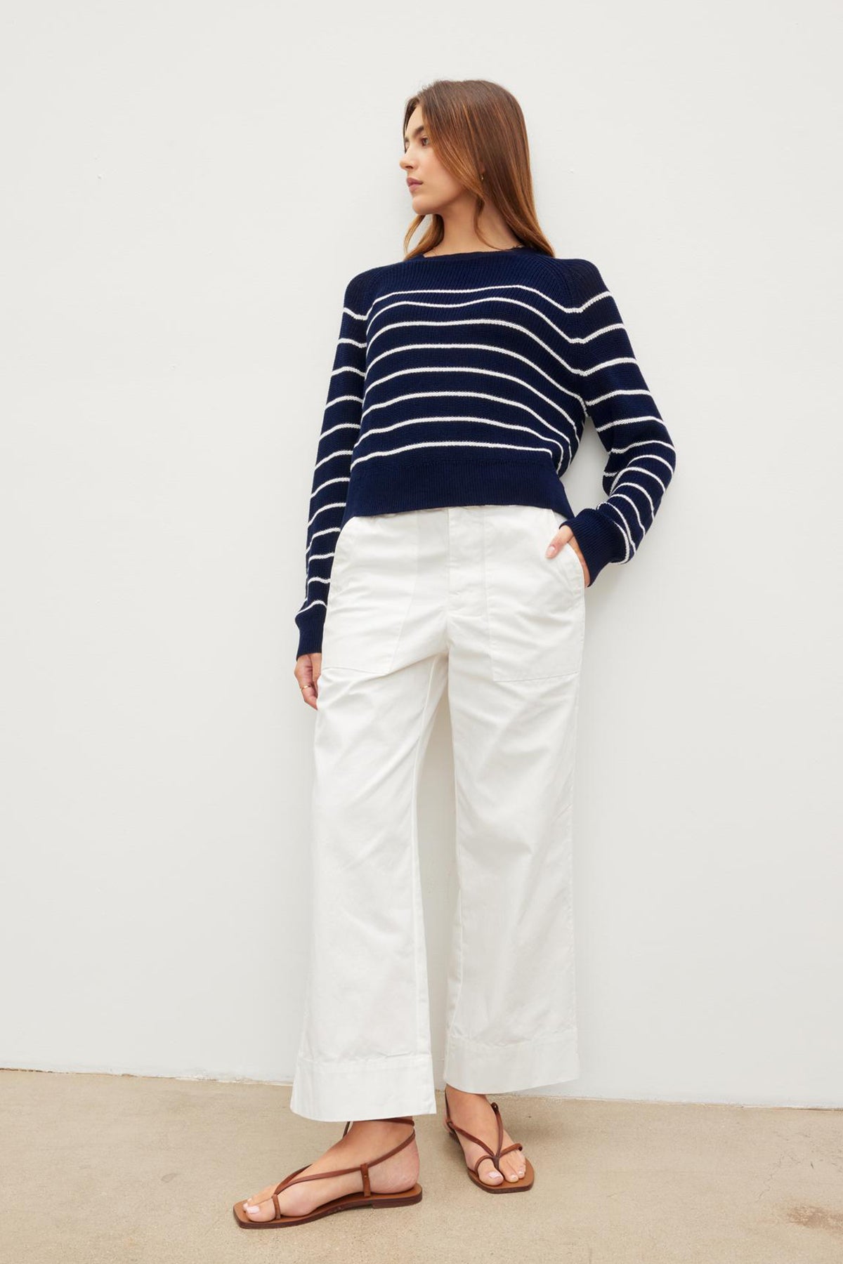 The model is wearing a navy striped sweater and white flared leg MYA COTTON CANVAS PANTS by Velvet by Graham & Spencer.-36161278148801