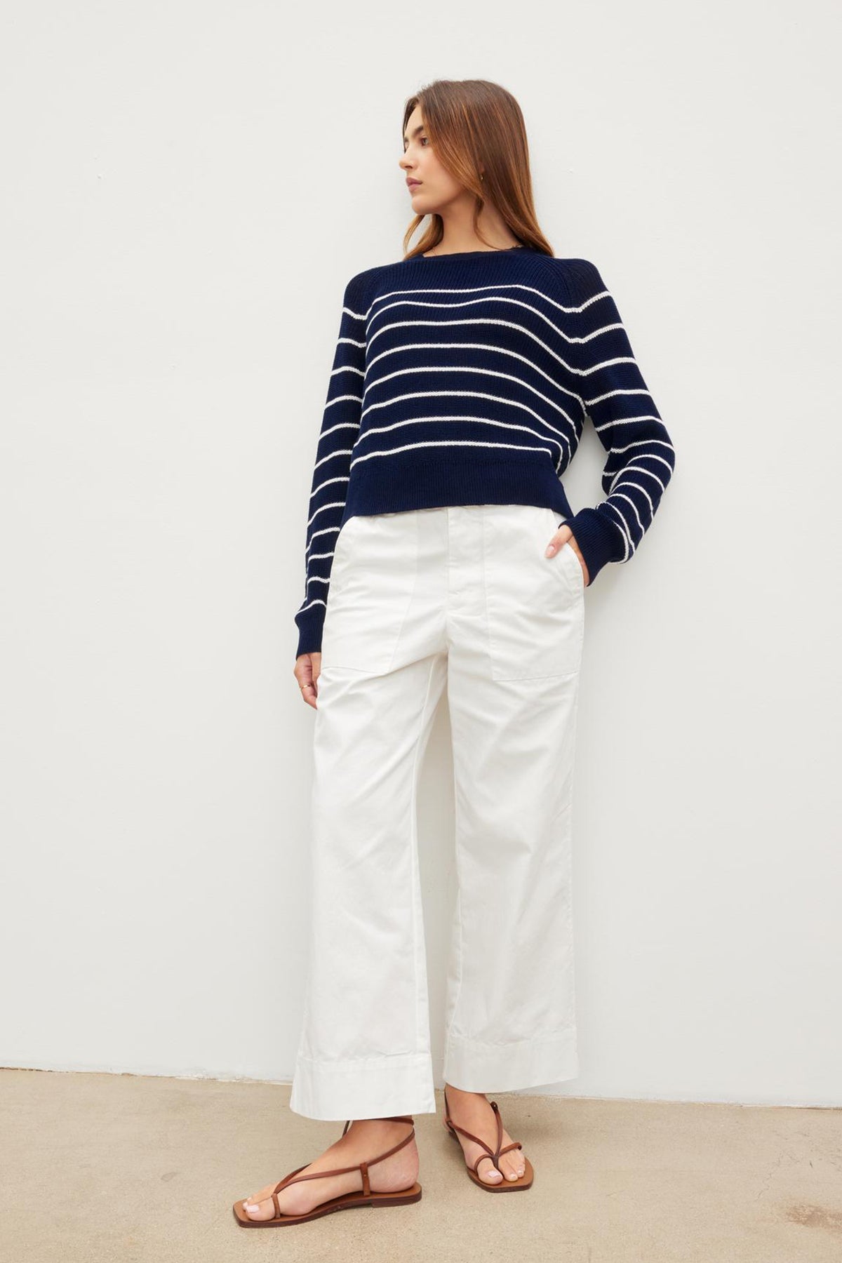   The model is wearing a navy striped sweater and white flared leg MYA COTTON CANVAS PANTS by Velvet by Graham & Spencer. 