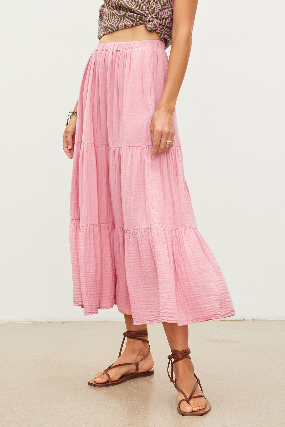 An essential woman's outfit featuring a pink ruffled DANIELLE COTTON GAUZE TIERED SKIRT made by Velvet by Graham & Spencer and paired with comfortable sandals.-35955694174401