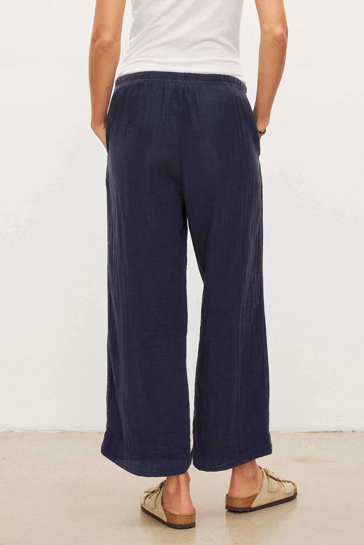 The back view of a woman wearing Velvet by Graham & Spencer's FRANNY COTTON GAUZE PANT, with a relaxed leg.-35955718095041