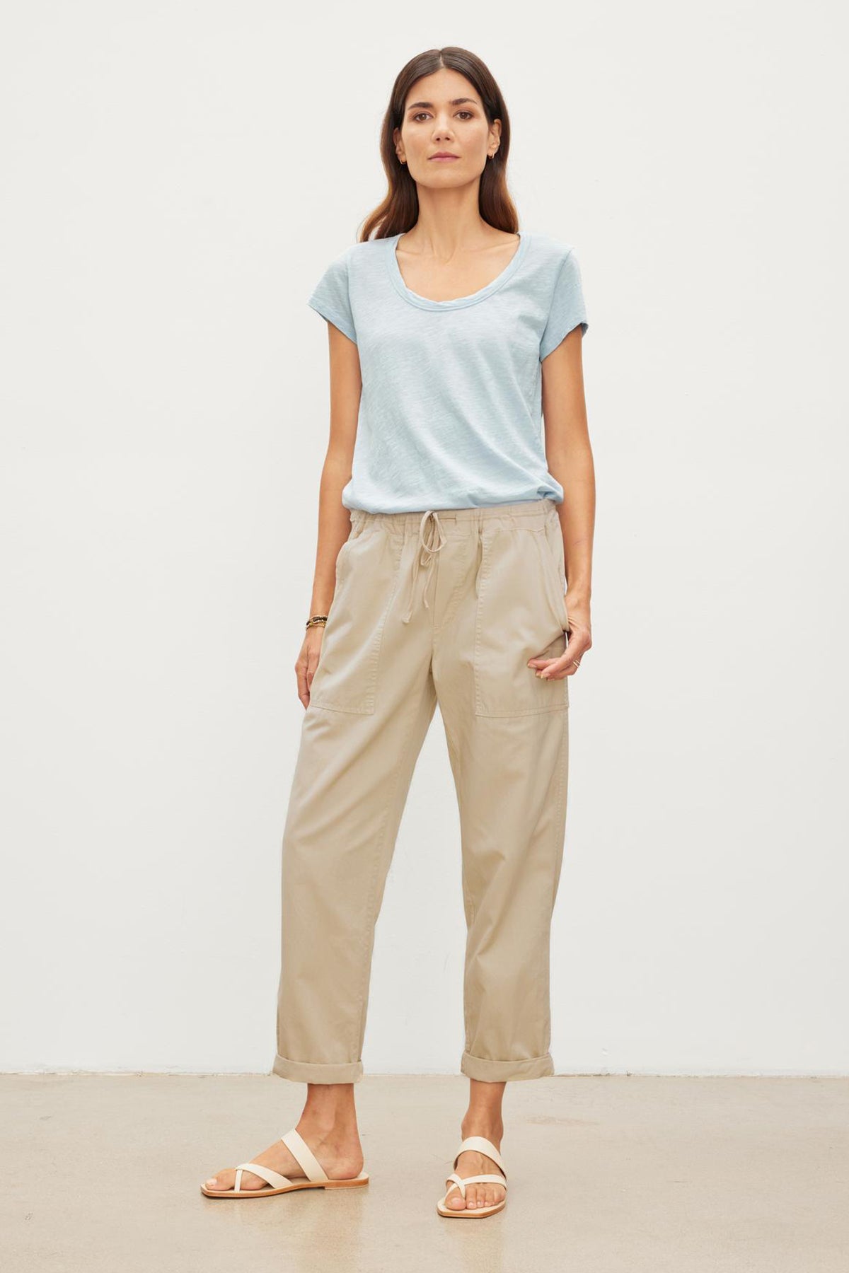   The model is wearing a blue t-shirt and Velvet by Graham & Spencer khaki pants. The MISTY COTTON TWILL PANT has an elastic waist and drawstring, providing comfort and adjustability. 