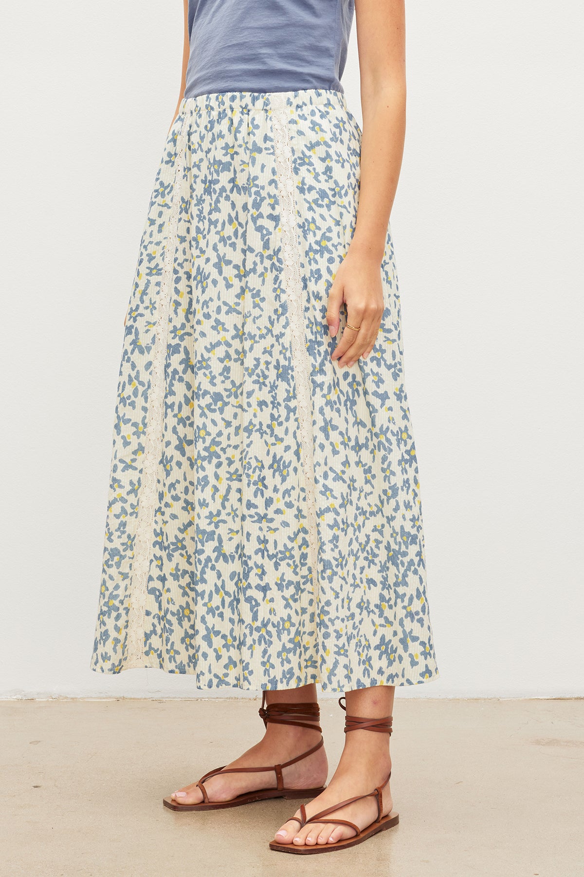   A woman wearing a KONA FLORAL LACE MAXI SKIRT from Velvet by Graham & Spencer with an elastic waist. 