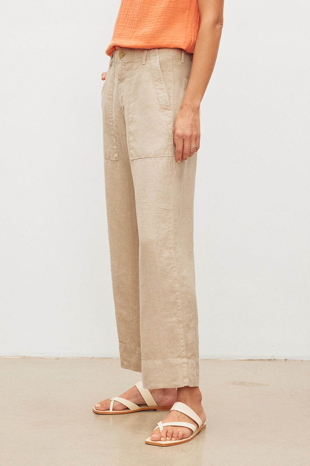 A person standing in a Velvet by Graham & Spencer DRU HEAVY LINEN PANT with patch pockets and white sandals against a plain background.-36247915659457